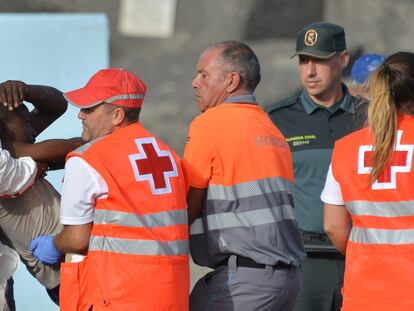 Los servicios de emergencia atienden a una de las 316 personas que han llegado este domingo a bordo de dos cayucos al puerto de La Restinga, en El Hierro, rescatados por Salvamento Marítimo.