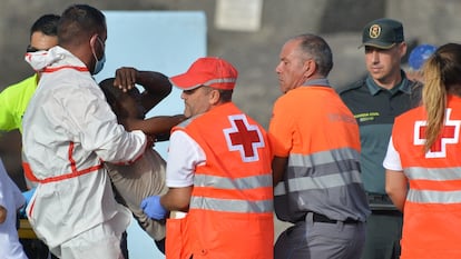 Los servicios de emergencia atienden a una de las 316 personas que han llegado este domingo a bordo de dos cayucos al puerto de La Restinga, en El Hierro, rescatados por Salvamento Marítimo.