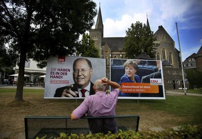 Un hombre observa los carteles electorales de la CDU y del SPD, en Olpe (Alemania), el 30 de agosto de 2013.