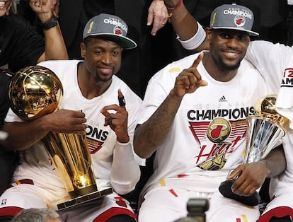 Dwyane Wade y LeBron con los trofeos de campeones