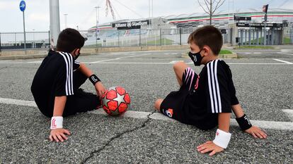 Niños, frente a un estadio de fútbol.