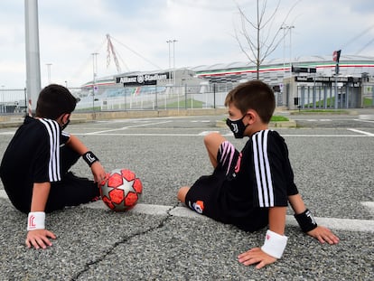 Niños, frente a un estadio de fútbol.