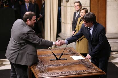 El vicepresident, Oriol Junqueras, que també assumeix la Conselleria d'Economia i Hisenda, saluda el president Puigdemont després de prometre el càrrec.