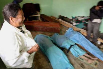 Una mujer llora frente a los cadáveres de tres miembros de su familia en Tecpan, al oeste de la ciudad de Guatemala.