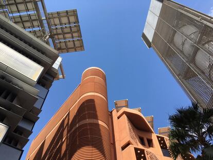 Una de las imágenes más representativas de Masdar. Nada más entrar a la ciudad, se accede a una plaza en la que confluyen las construcciones más características de la ciudad. En la imagen se ve un edificio con paneles solares en su cubierta, para lograr el autoabastecimiento y la torre de viento, que sirve para extender las corrientes de aire por las calles.