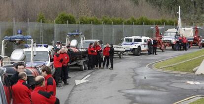 Agentes de la Ertzaintza esperan junto a sus vehículos.