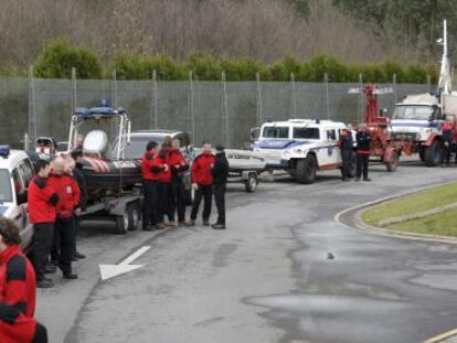 Agentes de la Ertzaintza esperan junto a sus vehículos.