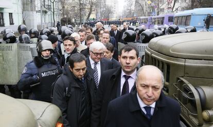 El ministro de AAEE alem&aacute;n, Frank-Walter Steinmeier (3d), y su hom&oacute;logo franc&eacute;s Laurent Fabius, avanzan escoltados por la polic&iacute;a antidisturbios en Kiev para entrevistarse con el presidente Yanukovych. Los enviados de la UE se han entrevistado tambi&eacute;n con dirigientes de la oposici&oacute;n. 