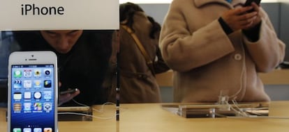 Un joven probando un modelo de iPhone en una tienda de Apple en Pekín.