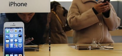 Un joven probando un modelo de iPhone en una tienda de Apple en Pek&iacute;n. 