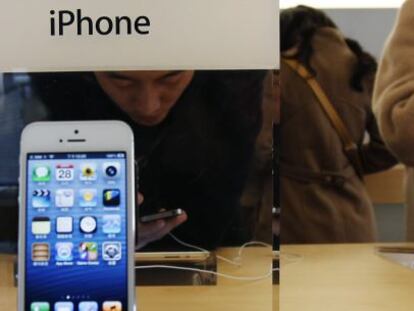 Un joven probando un modelo de iPhone en una tienda de Apple en Pek&iacute;n. 