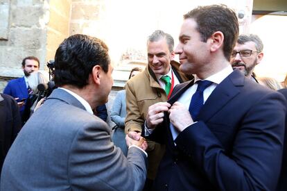 El líder del PP andaluz, Juan Manuel Moreno, saluda al secretario general de Vox, Javier Ortega (con corbata verde), ante Teodoro García Egea.