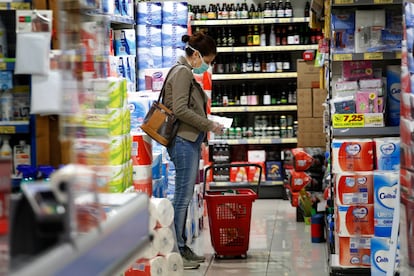 Una mujer, ante la sección de bebidas alcohólicas de un supermercado.