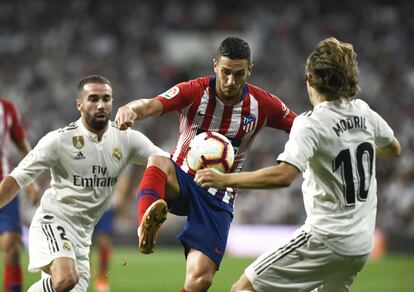 Koke, en el centro, se hace con el control del balón ante Carvajal y Modric.