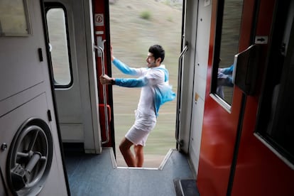 Sinan Usta, de 24 anos, posa para um selfie em uma porta aberta enquanto o trem segue seu caminho.