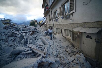 Un home porta un cotxet a Amatrice.