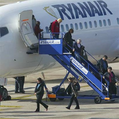 Un grupo de pasajeros desciende de un avión de Ryanair en el aeropuerto de Girona, su principal centro de operaciones en España.