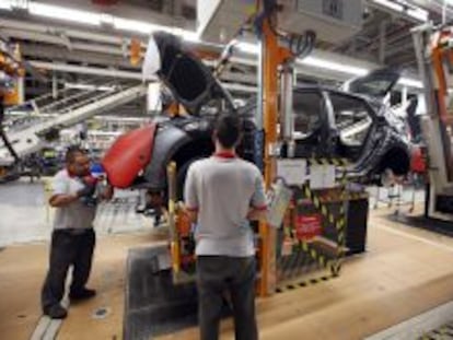 Dos trabajadores en la cadena de montaje de la f&aacute;brica de Seat en Martorell.