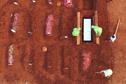 Vista aérea de dos sepulteros enterrando víctimas de la Covid en el cementerio de Pondok Ranggon, en Yakarta (Indonesia).