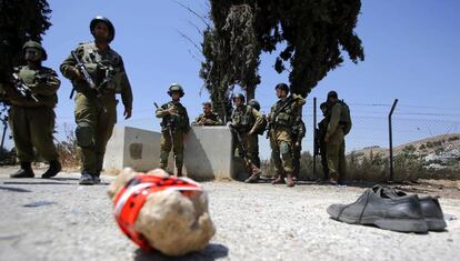 Soldados israel&iacute;es junto a un par de zapatos, supuestamente del atacante palestino que el lunes hiri&oacute; a dos militares al norte de Hebr&oacute;n. 