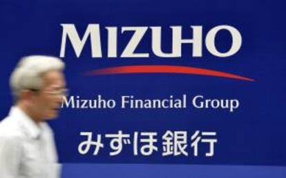 Un peatn pasa por delante de la sede del Banco Mizuho en Tokio, Japn. EFE/Archivo