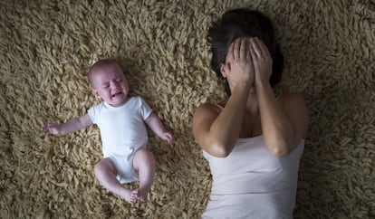 Una madre agotada con su bebé.