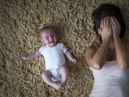 Una madre agotada con su bebé.