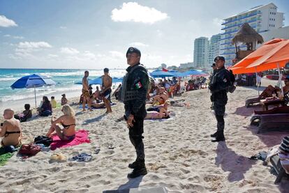 Policías federales de México vigilan una playa de Cancún.