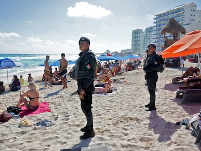 Policías federales de México vigilan una playa de Cancún.