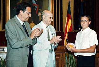 Macià (a la izquierda) y Grisolía entregan la Medalla de Oro a un niño de la Escolanía del Misteri.