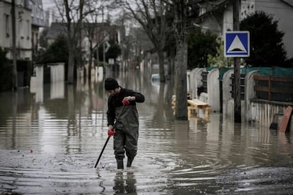 Un vecino limpia la calle inundada en Villeneuve-Saint-Georges, al sur de París, el 25 de junio de 2018. 