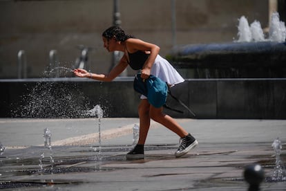 Una chica se refresca en una fuente de Sevilla durante la cuarta ola de calor del verano. 
