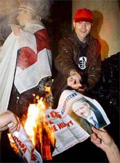 Jóvenes contrarios a Kukashenko queman un periódico con su imagen.