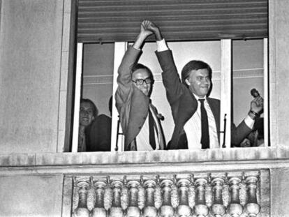 Alfonso Guerra levanta la mano de Felipe Gonz&aacute;lez, asomados a una ventana del hotel Palace, tras conocerse la victoria socialista en 1982.