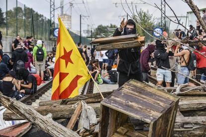 Un manifestante lanza madera para obstruir las vías del AVE durante la protesta contra la sentencia del 'procés' en Barcelona.