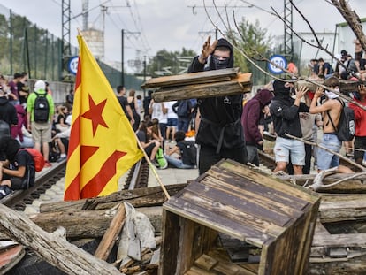 Un manifestante lanza madera para obstruir las vías del AVE durante la protesta contra la sentencia del 'procés' en Barcelona.