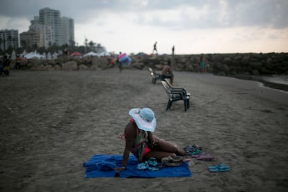 Una mujer revisa su teléfono móvil en la playa de Cartagena, Colombia, en una fotografía de archivo.