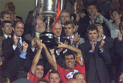 Los jugadores Marcos y Nadal, capitán del equipo, levantan la Copa que acaba de entregarles el Rey.