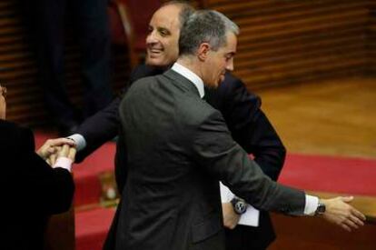El presidente valenciano, Francisco Camps, junto a Ricardo Costa,  saluda a un diputado en las Cortes tras la sesión de control.