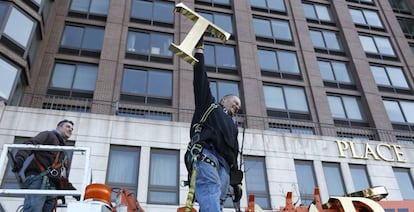 Um funcionário retira as letras do complexo Trump Place.