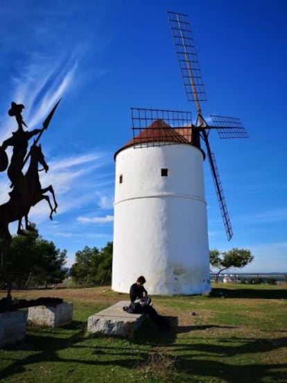 Un molino de viento junto a un perfil metálico de Don Quijote, a las afueras de Almodóvar del Campo.