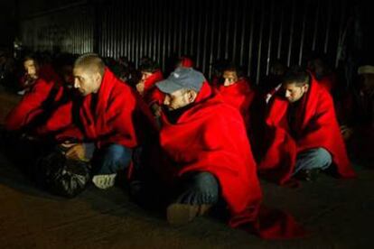 Los inmigrantes interceptados el viernes en el Estrecho se calientan con mantas de la Cruz Roja.