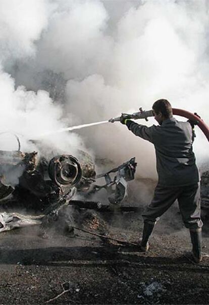 Un bombero iraquí apaga el fuego del coche bomba que ha estallado en la <i>zona verde</i> de Bagdad.