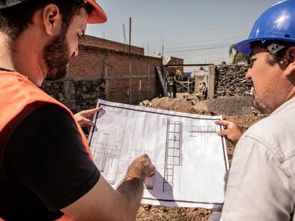 Un ingeniero y un encargado de obra revisan una construcción.