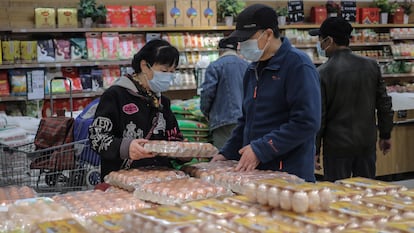 Várias pessoas compram em um supermercado de Pequim (China), nesta terça-feira.