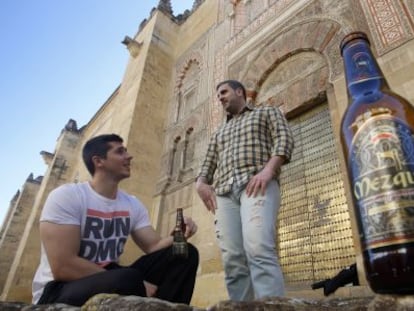 Dos jóvenes beben cerveza Mezquita junto al monumento cordobés.