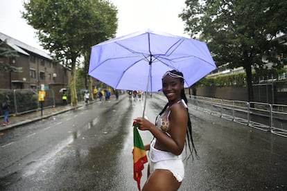 Una mujer posa con su paraguas, en el primer día del Carnaval de Notting Hill, una jornada pasada por agua.