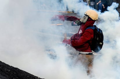 Un activista opositor lanza un bote de gas lacrimógeno a la policía durante una manifestación en Caracas, el 26 de junio de 2017.