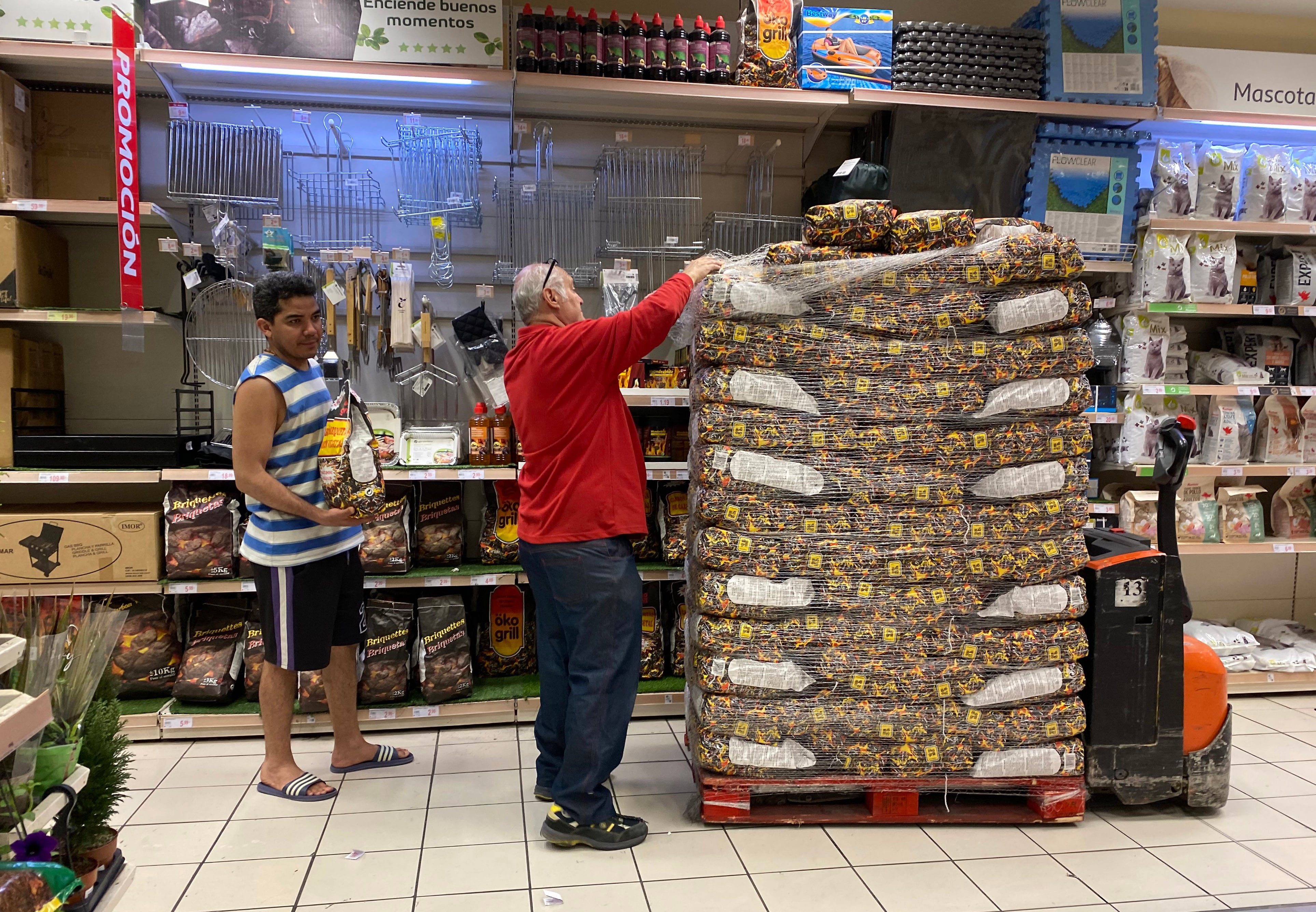 28 04 2025. Madrid. Un reponedor carga bolsas de carbón en una de las estanterías del supermercado Alcampo de Vallecas.