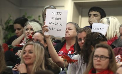 Una madre que se opone a las vacunas sostiene un cartel contra la nueva ley, el mi&eacute;rcoles en el Senado de Sacramento.